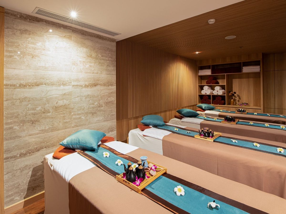 Twin massage beds with folded towels in a wood-panelled treatment room