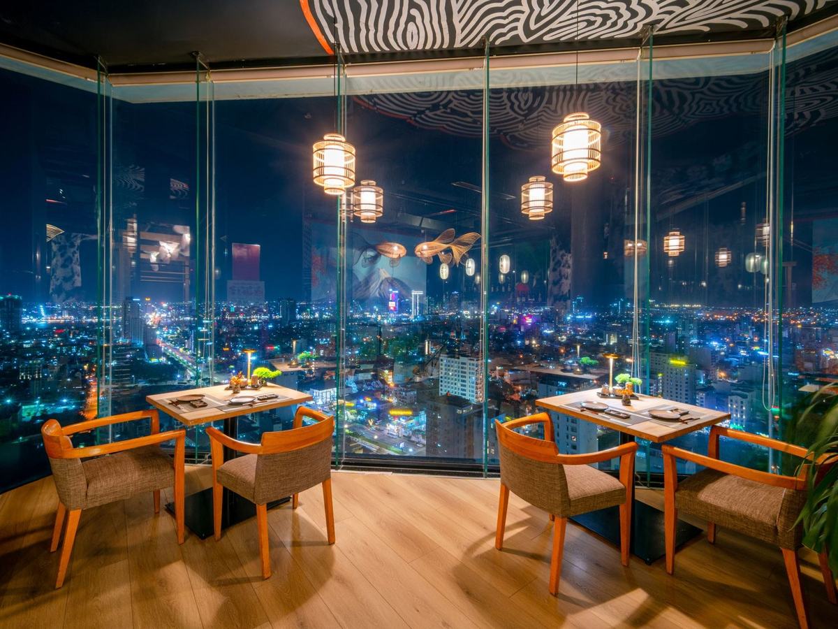 Japanese restaurant at night with paper lanterns and wooden tables beside floor-to-ceiling windows over city lights