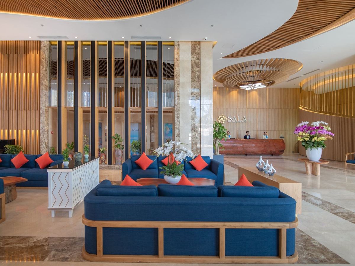 Lobby lounge with blue sofas, wooden screens and flower arrangements