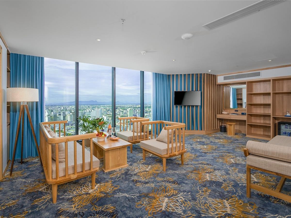 Japanese-style suite with a blue patterned carpet, wooden armchairs and a wide window over the city and sea